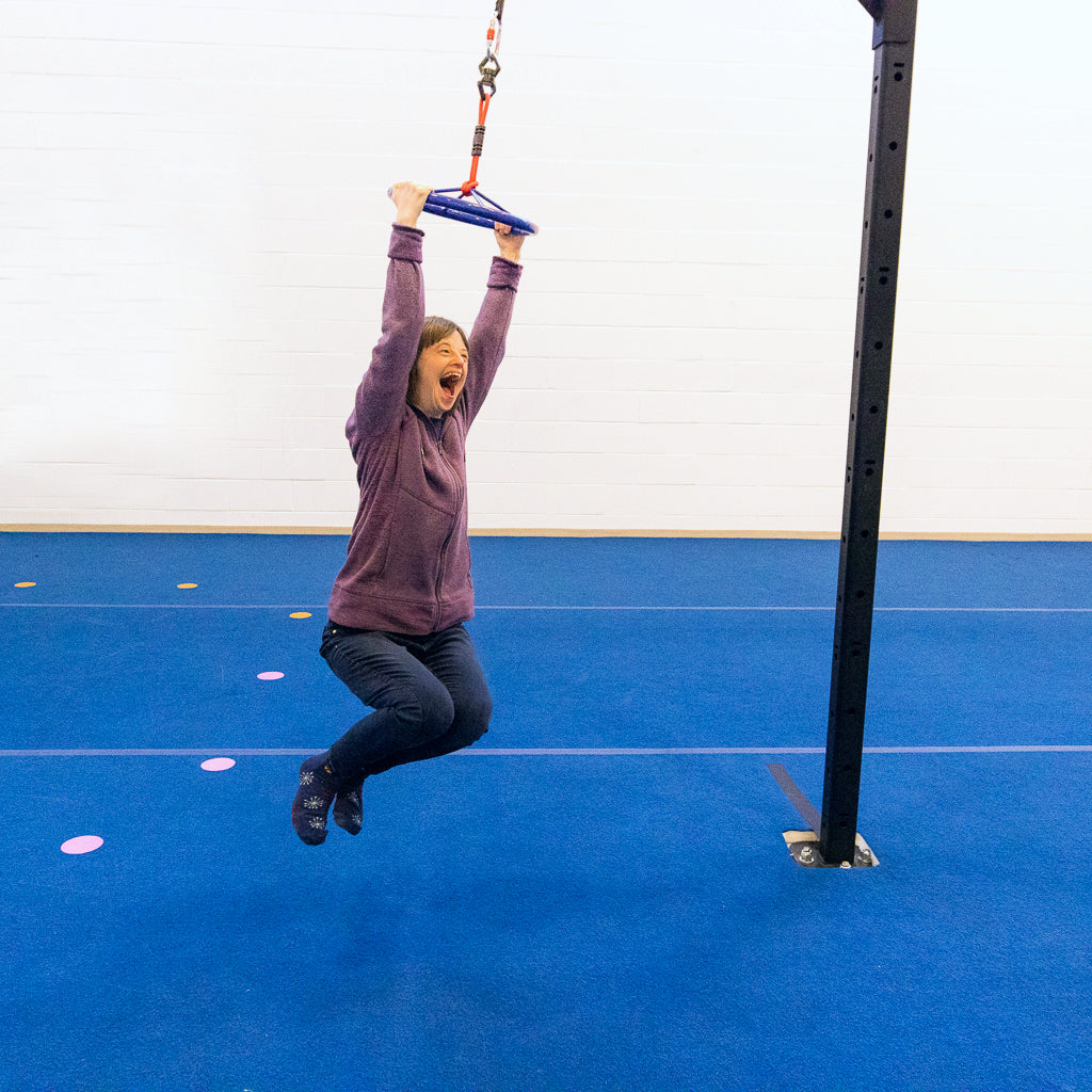 A young woman smiling and having fun spinning on a ninja wheel