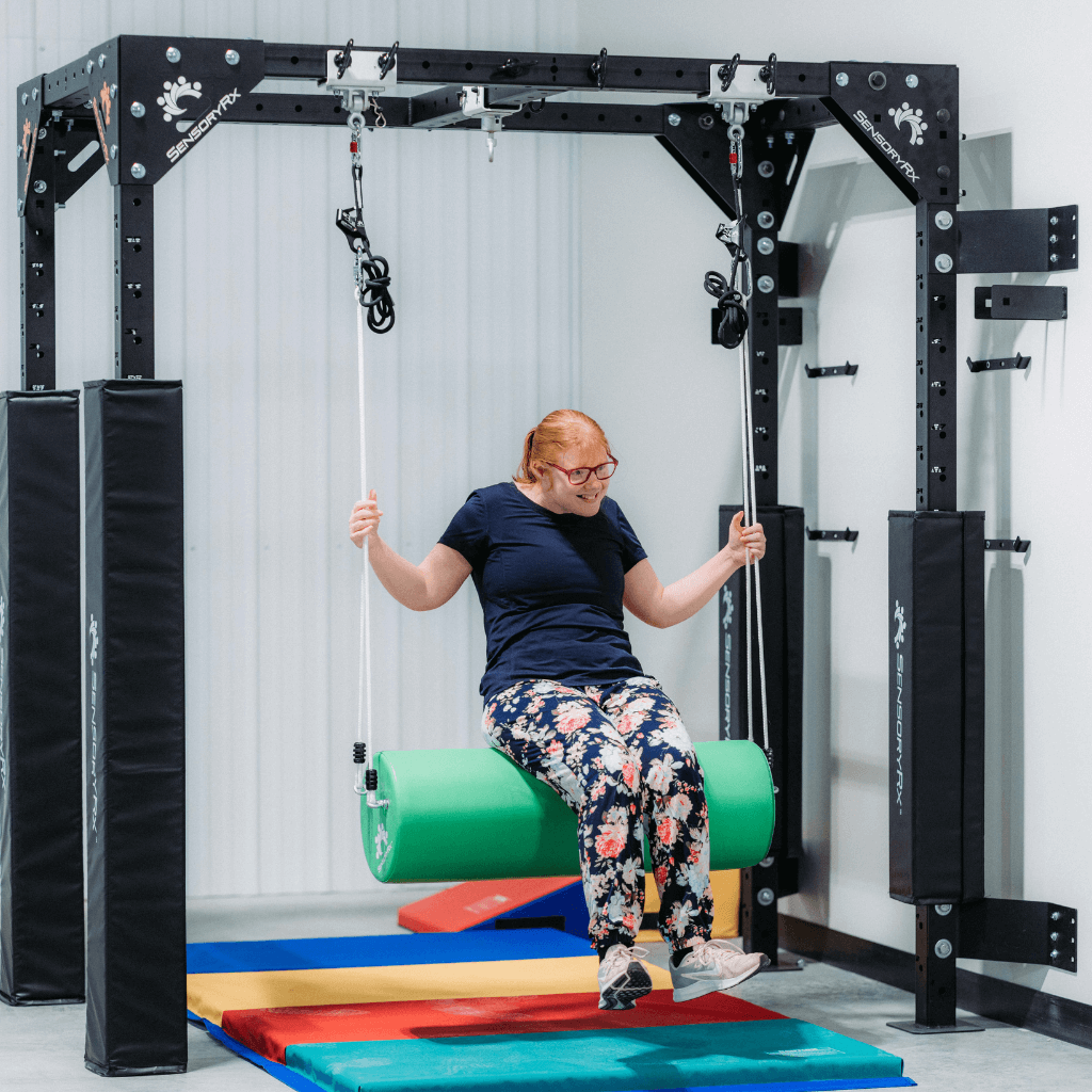 A woman with sensory needs on a bolster swing