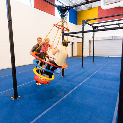 Two girls on a SwRing being pushed by an occupational therapist