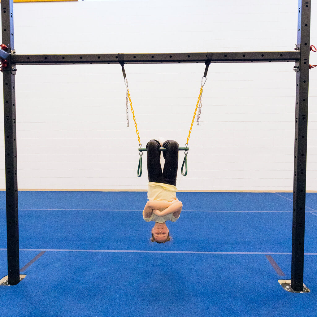 A girl hanging upside down on a sensory trapeze bar