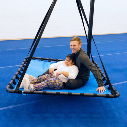 A woman with cerebral palsy enjoying a sensory swing while sitting with an occupational therapist