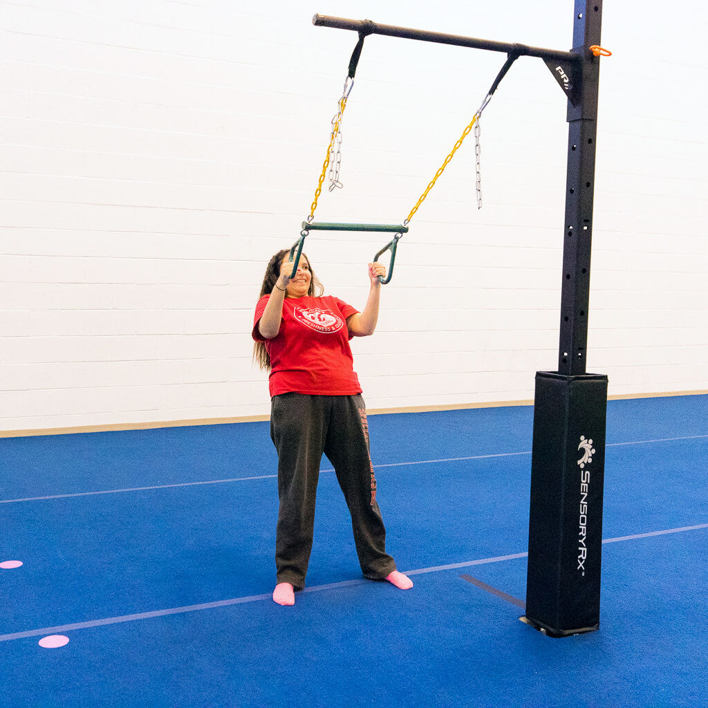 A young woman doing a modified row exercise with a trapeze bar swing