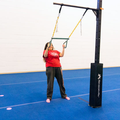 A young woman doing a modified row exercise with a trapeze bar swing